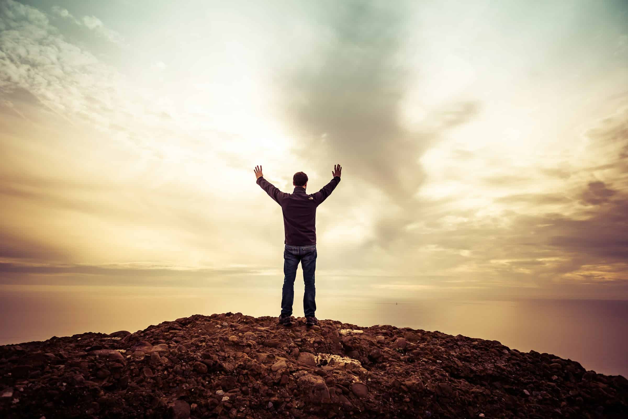 man expressing gratitude overlooking coast