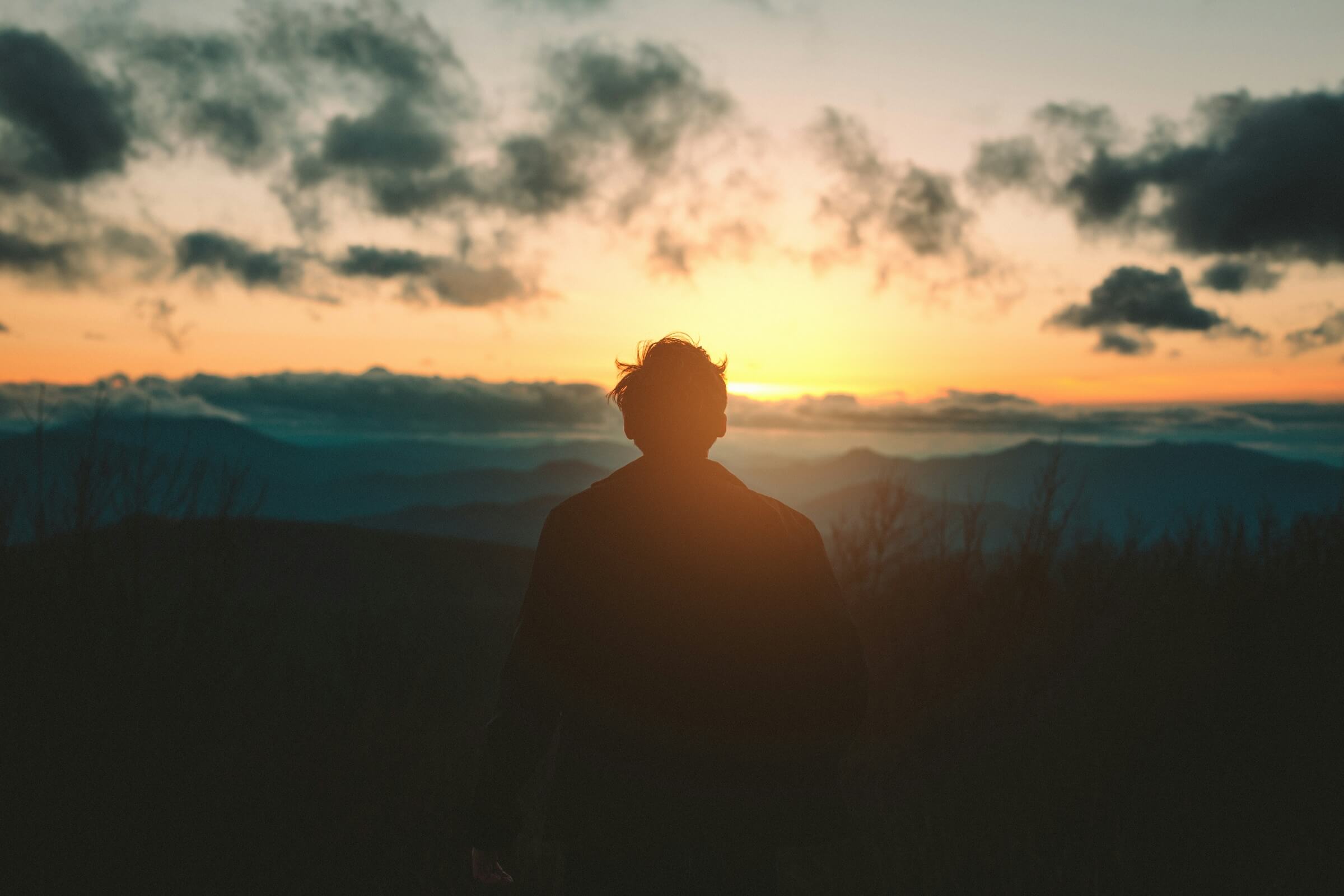 Greg Harris Coaching| image: man-reflecting-on-journey-through-mountains